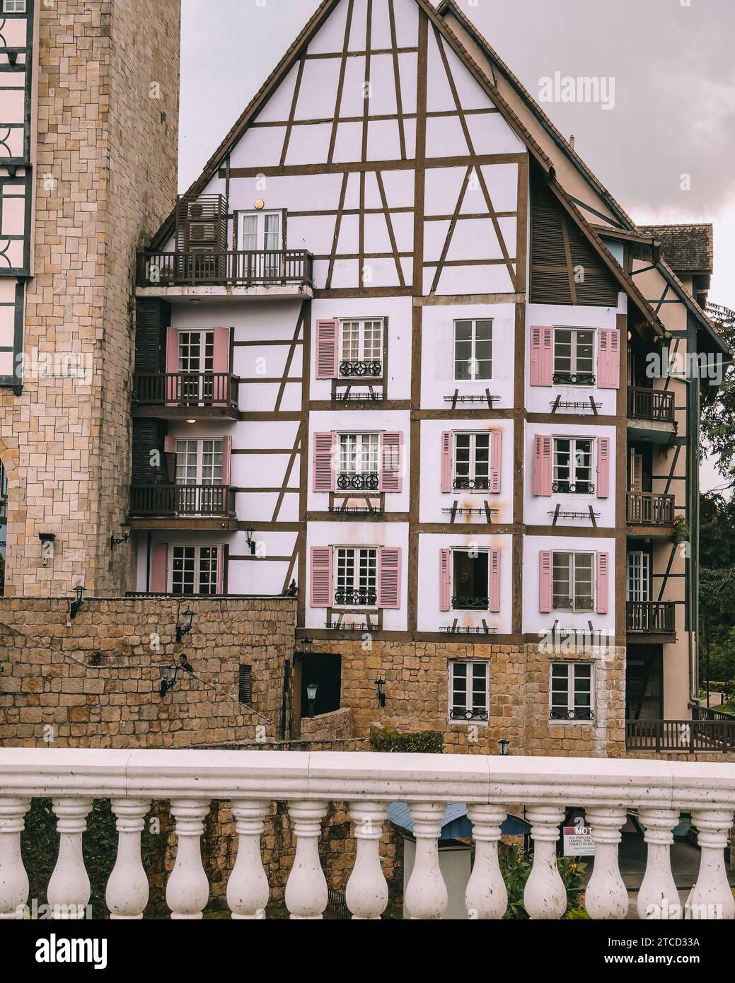 Un piccolo edificio in mattoni in un'area urbana, caratterizzato da persiane rosse sulla sua facciata Foto Stock