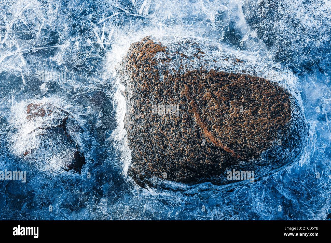 Costa invernale con acqua ghiacciata, rocce ghiacciate e pietre in Svezia Foto Stock