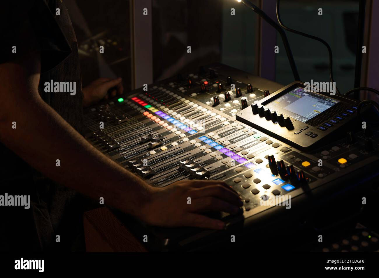 tecnico del suono non riconoscibile che utilizza una console di miscelazione multitraccia nella sala di controllo durante un evento Foto Stock