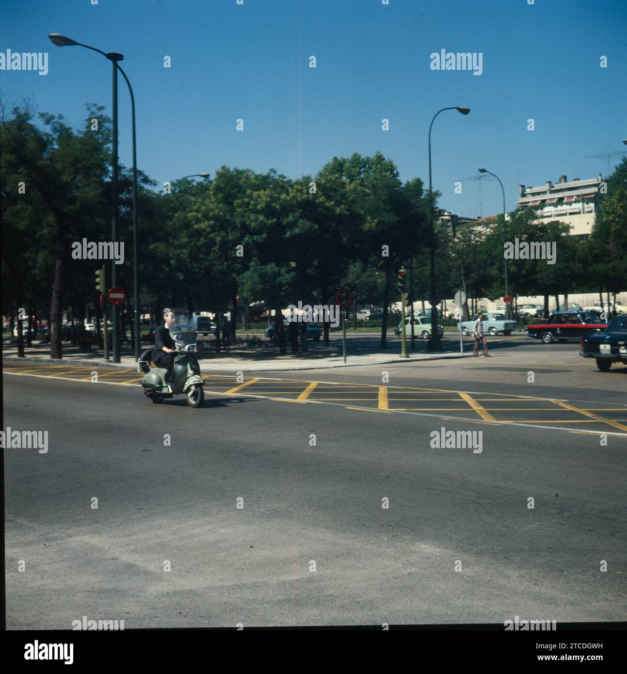 Madrid, intorno al 1975. Uno scooter che viaggia lungo il Paseo de la Castellana. Sulla destra potete vedere alcune delle auto tipiche dell'epoca, come un taxi Seat 1500 o un Seat 600. Crediti: Album / Archivo ABC Foto Stock