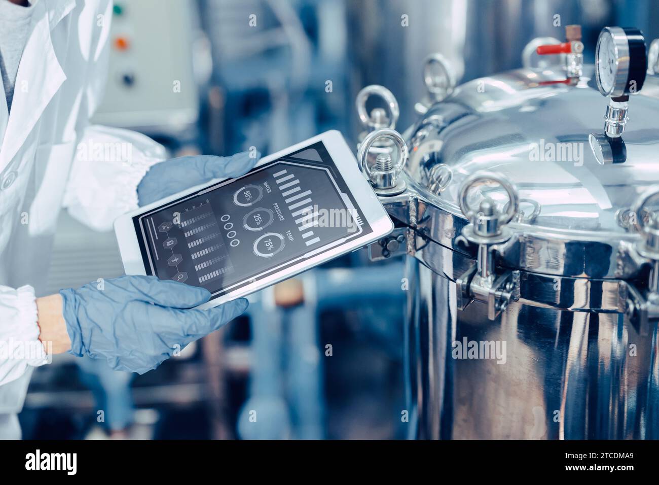 closeup ingegnere lavoratore tablet in fabbrica di alimenti e bevande monitor operare controllo ispezionare linea di produzione alta pressione serbatoio di produzione li Foto Stock