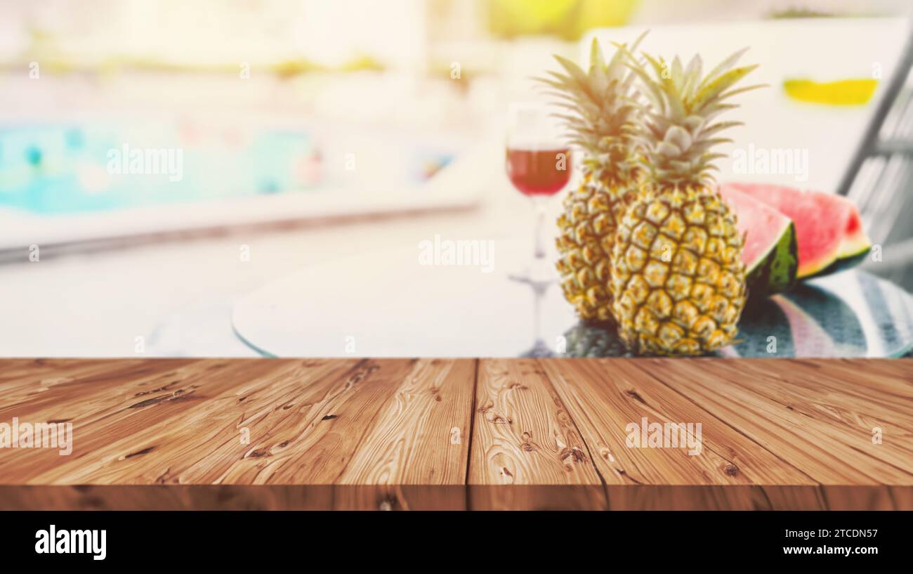 sfocate la bevanda di frutta tropicale sul tavolo a lato della piscina nel resort dell'hotel sulla spiaggia con bancone in legno vuoto per il montaggio dei prodotti di viaggio della stagione estiva Foto Stock
