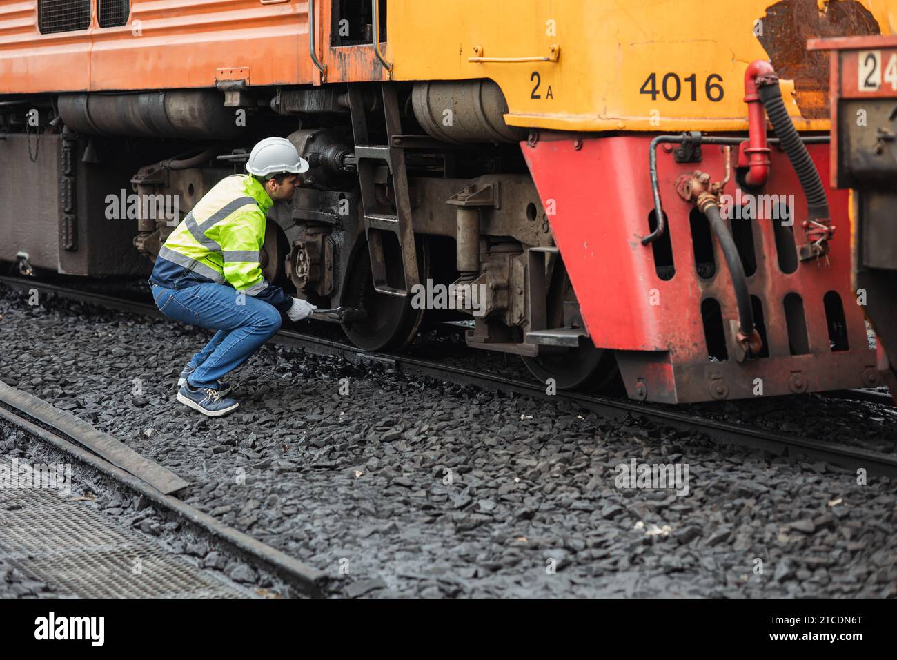 Addetto alla riparazione delle locomotive, tecnico del macchinista in servizio di manutenzione materiale rotabile della vecchia cabina del treno diesel per passeggeri nel trasporto ferroviario i Foto Stock