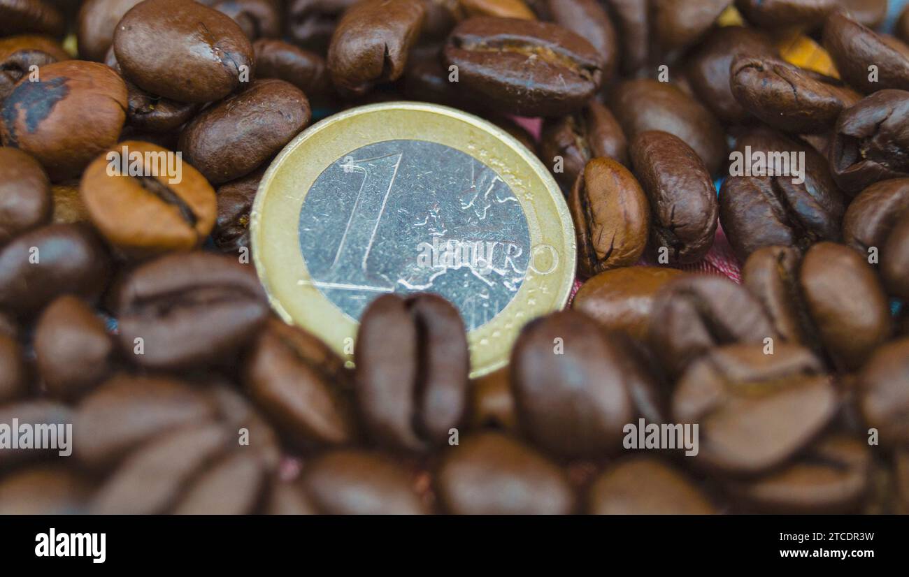 Chicchi di caffè tostati con moneta Euro, prezzo del caffè Foto Stock