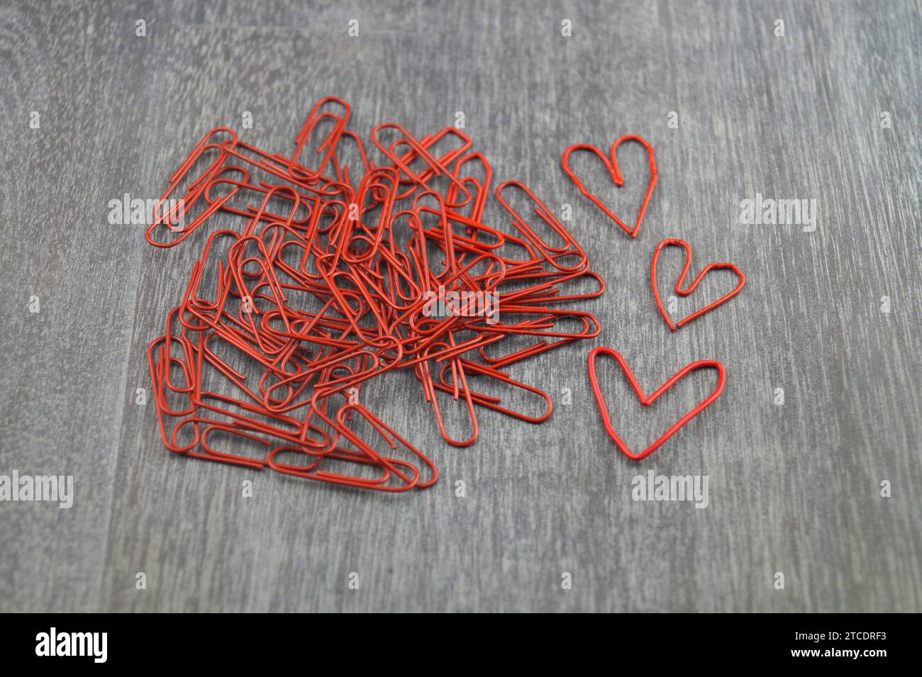 graffette rosse, tre delle quali a forma di cuore, amore in ufficio Foto Stock