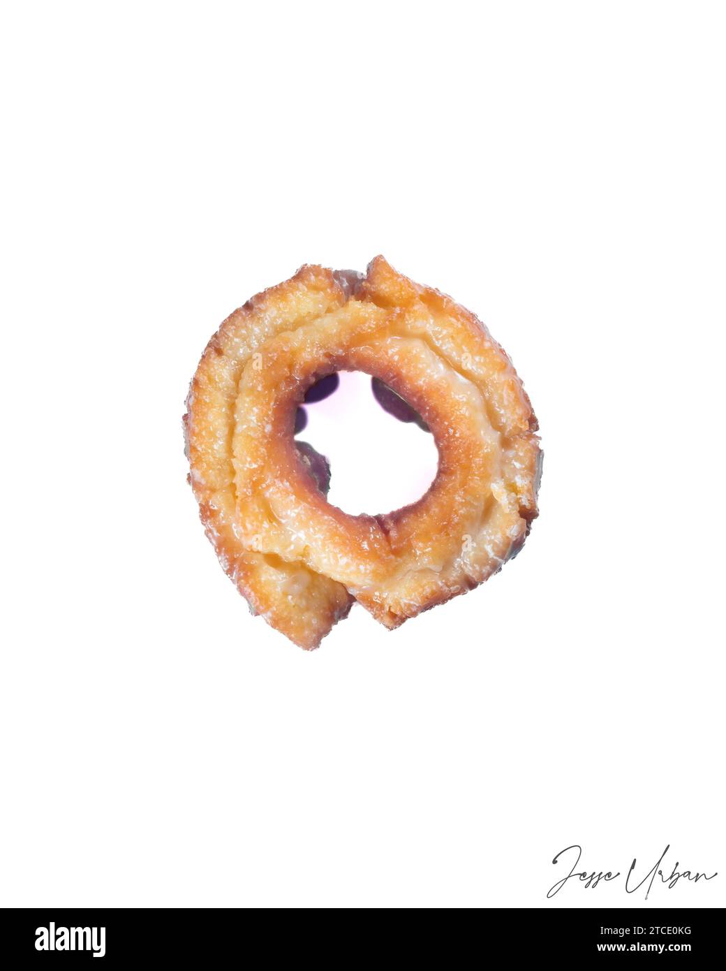 Una vista ravvicinata di un'unica ciambella al cioccolato con uno strato di zucchero bianco e una dozzina di latte bianco in cima Foto Stock