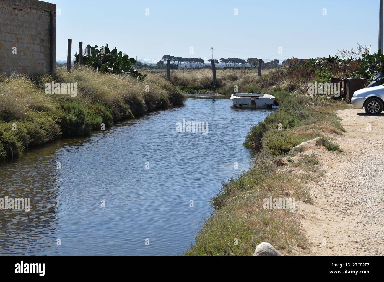 Piccolo torrente che serve come approvvigionamento di acqua salata dal mare presso le saline delle Saline di Trapani a Culcasi, in Sicilia Foto Stock