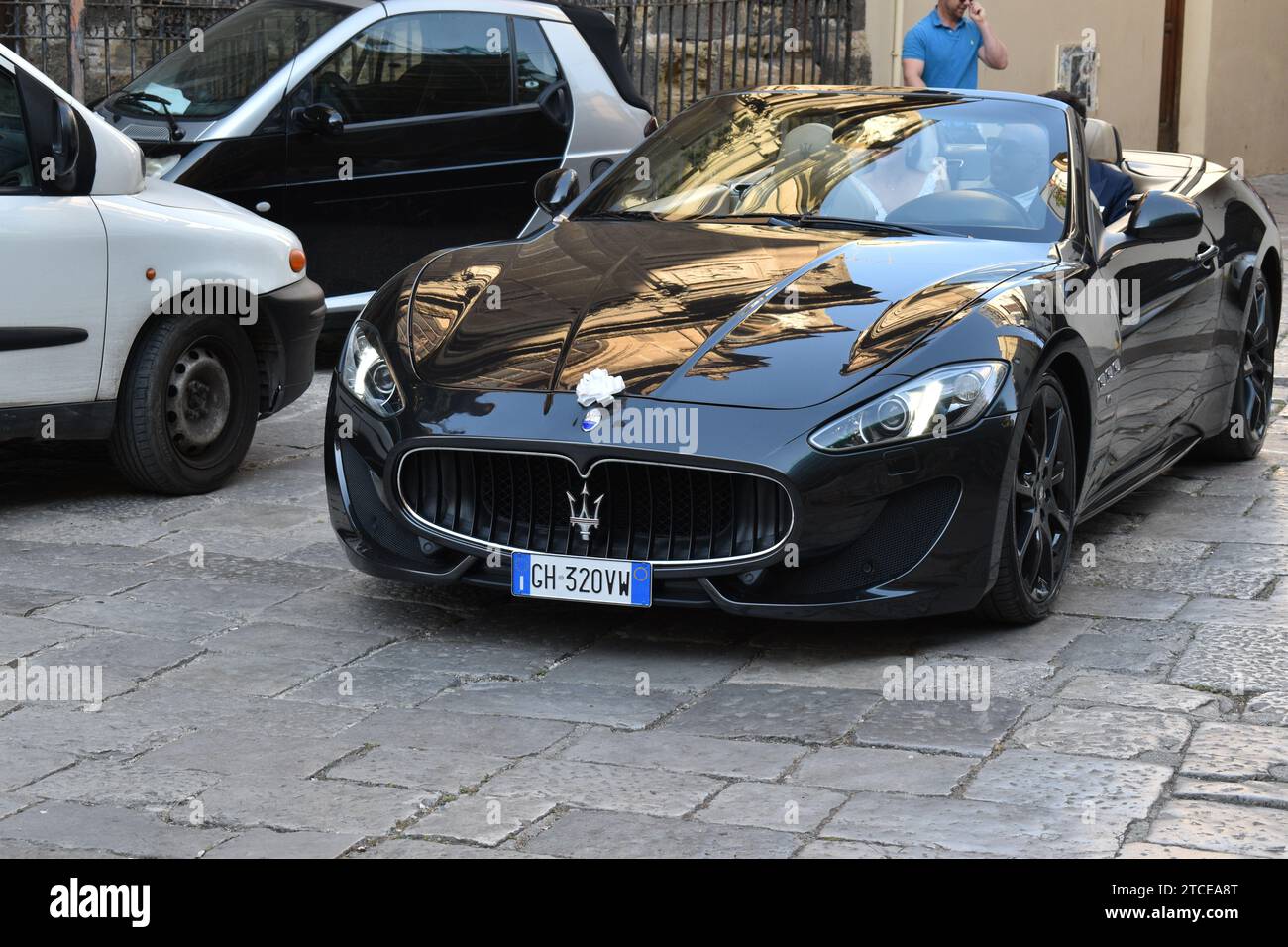 Una Maserati Gran Turismo nera brillante con un piccolo arco bianco sopra il logo dell'auto per le strade di Palermo Foto Stock