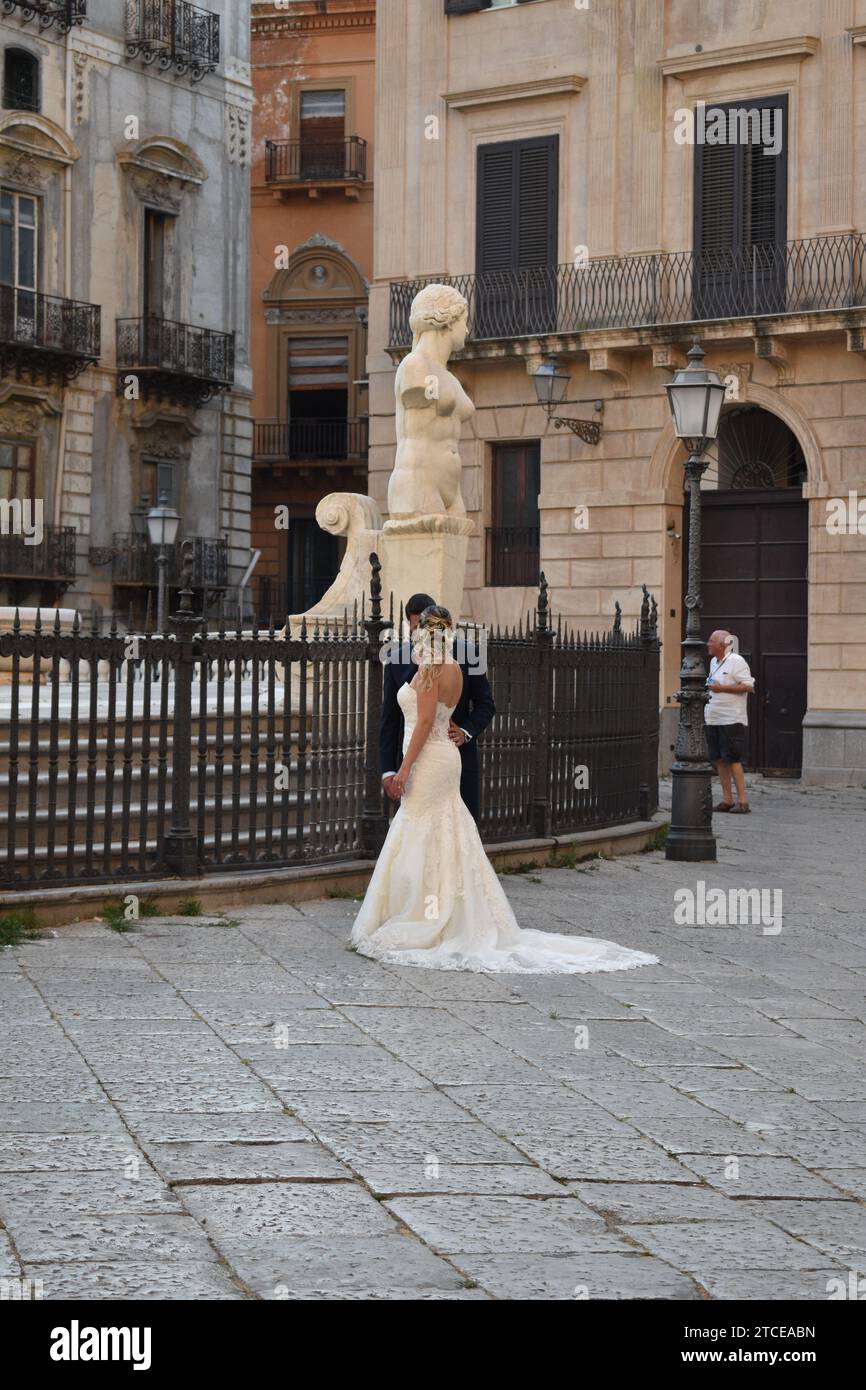 Sposi e sposi si guardano intimamente in Piazza Pretoria nella città di Palermo Foto Stock