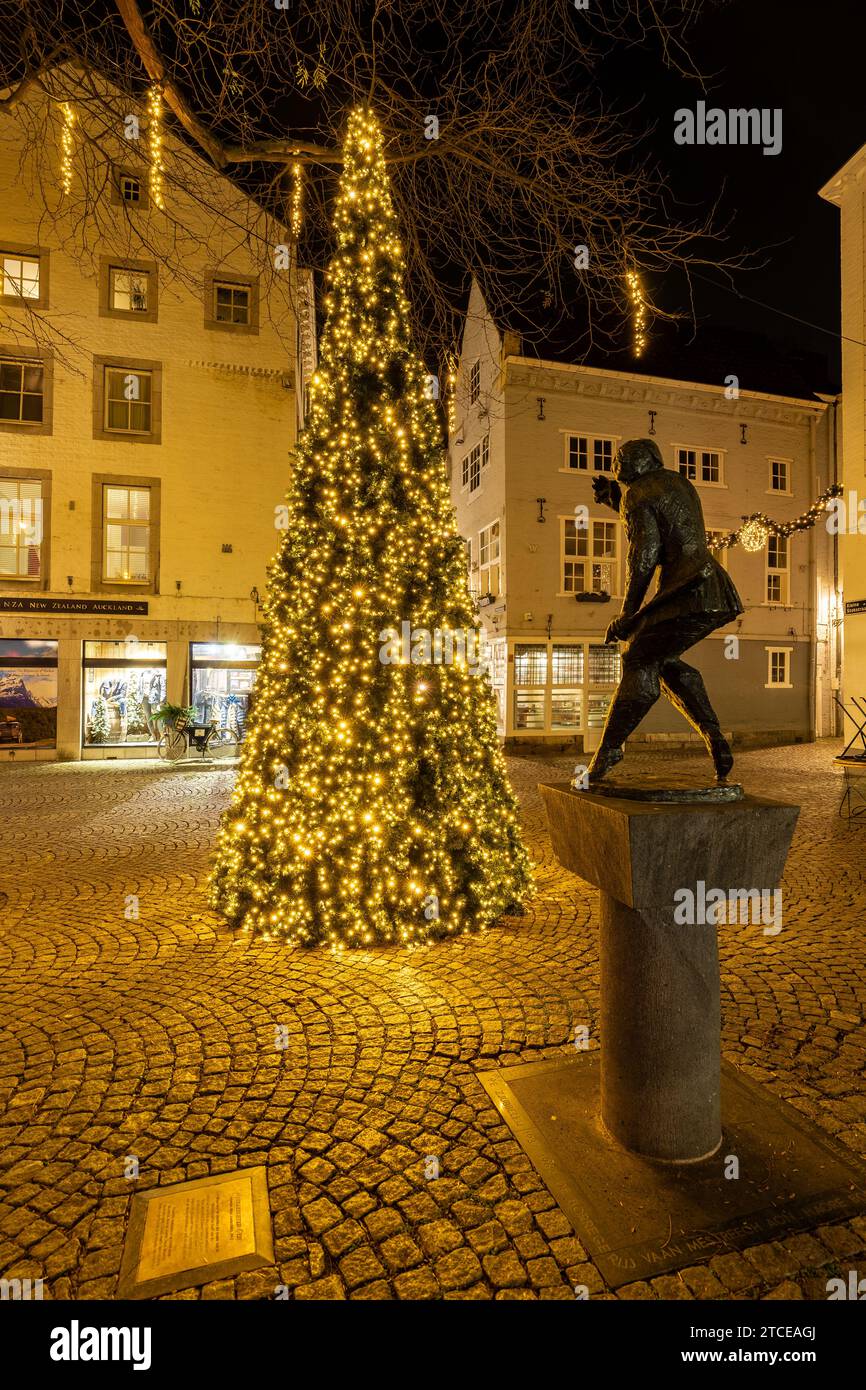 Mestreechter Geis o The Spirit of Maastricht circondato dalle luci natalizie. La statua riflette l’umorismo, la spiritualità e i creativi dei cittadini di Maastricht Foto Stock