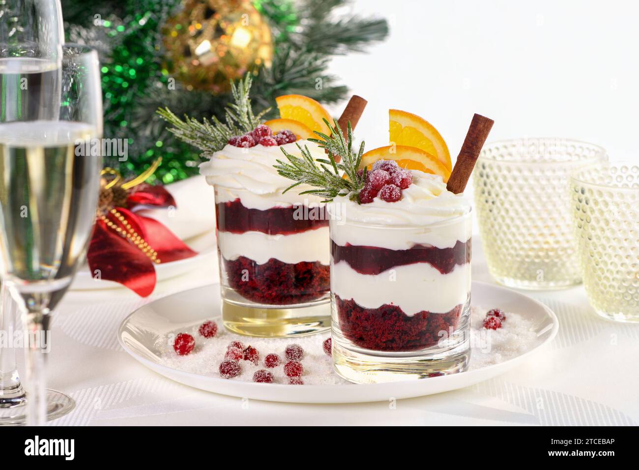 Dessert natalizio al miramisù con mascarpone e panna montata, biscotti al cioccolato sbriciolati e confettura di mirtilli, guarniti con fette di arancia, lattina Foto Stock