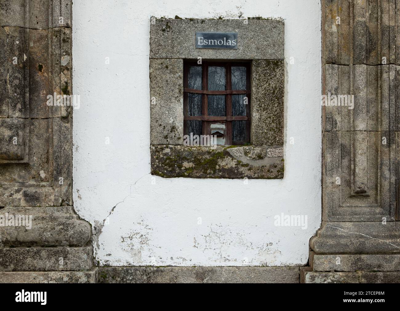 Facciata frontale della chiesa con piccola finestra per donazioni o elemosine, esmolas in portoghese Foto Stock