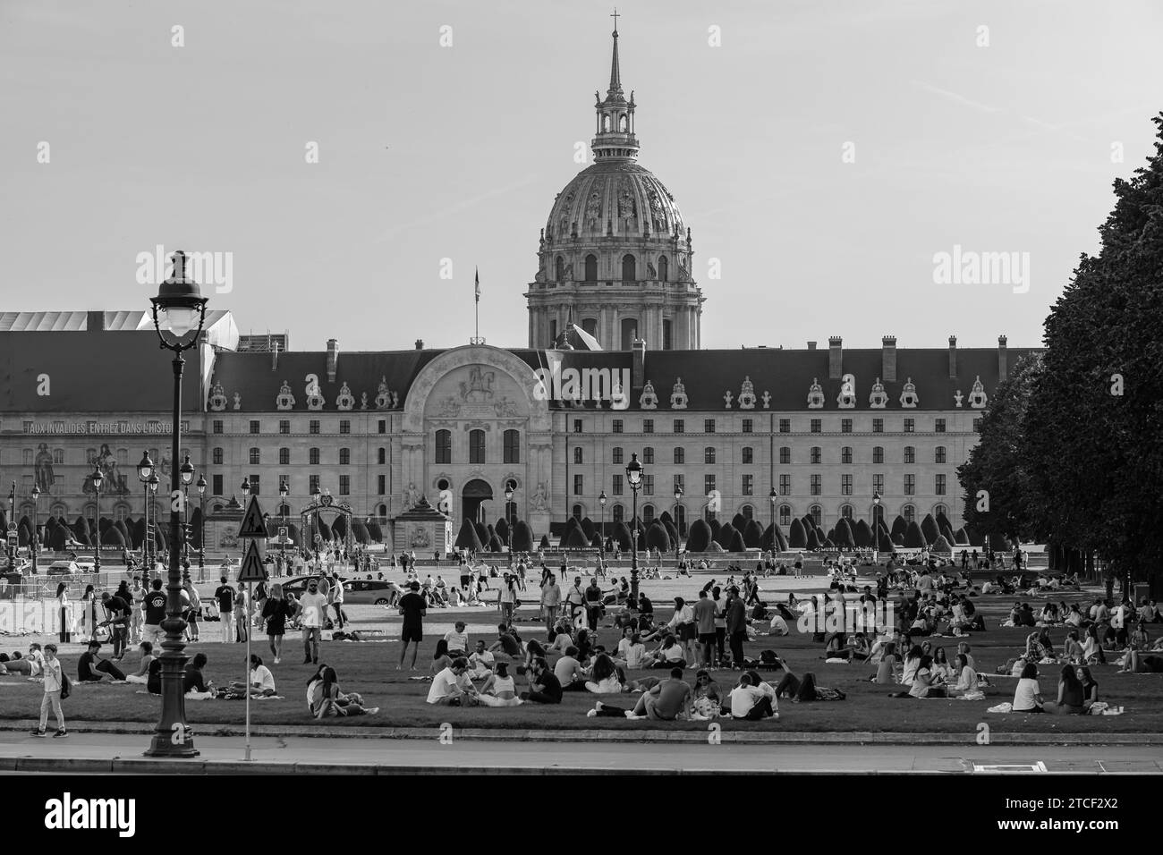 Parigi, Francia - 8 ottobre 2023: Veduta della folla di giovani seduti in piccoli gruppi in un parco verde di fronte all'Hotel des Invalides Foto Stock