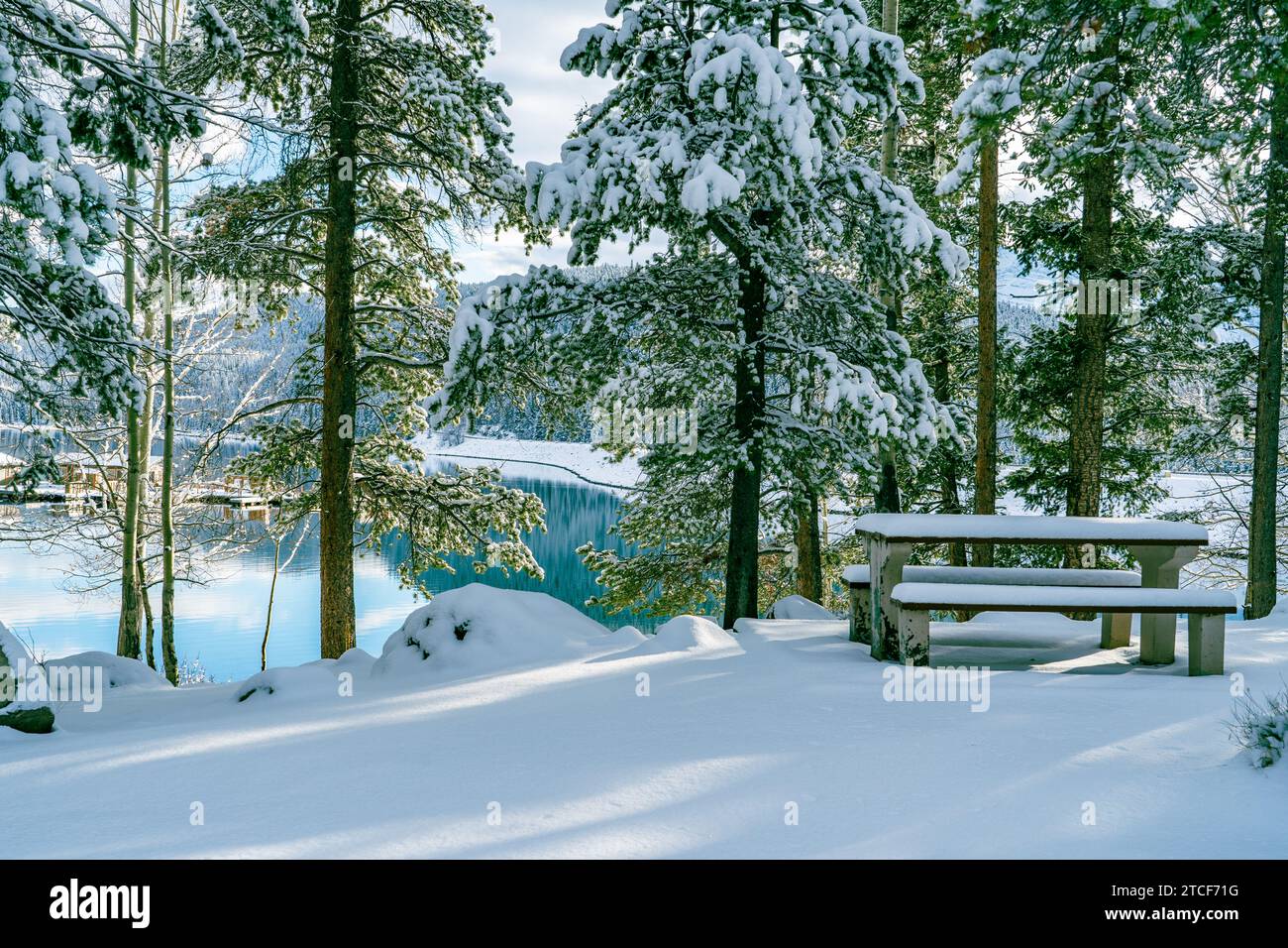 Tavolo da picnic coperto di neve al lago Minnewanka in inverno nelle Montagne Rocciose canadesi Foto Stock