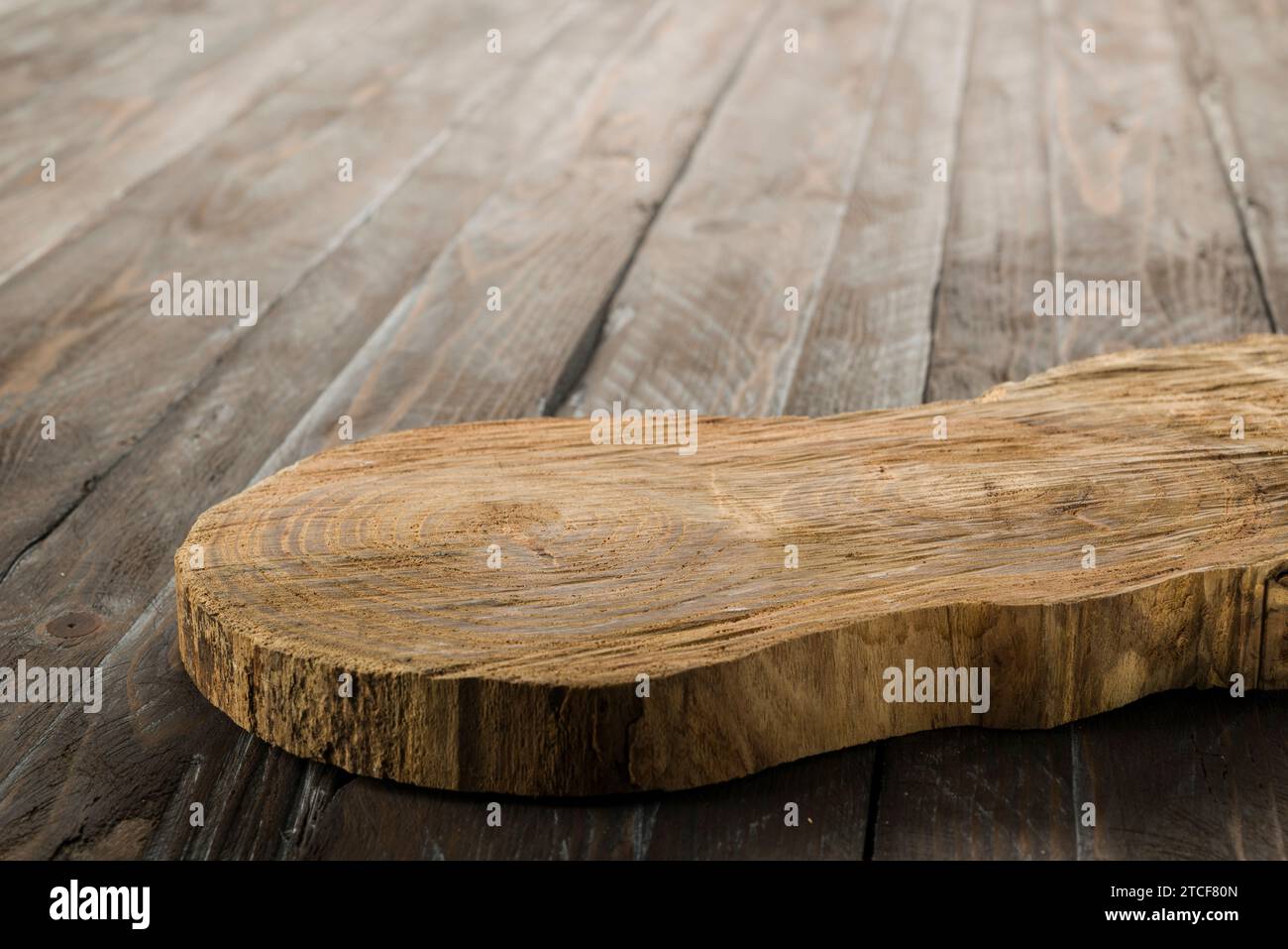 Tagliere rustico in legno isolato su tavola in legno. Foto Stock