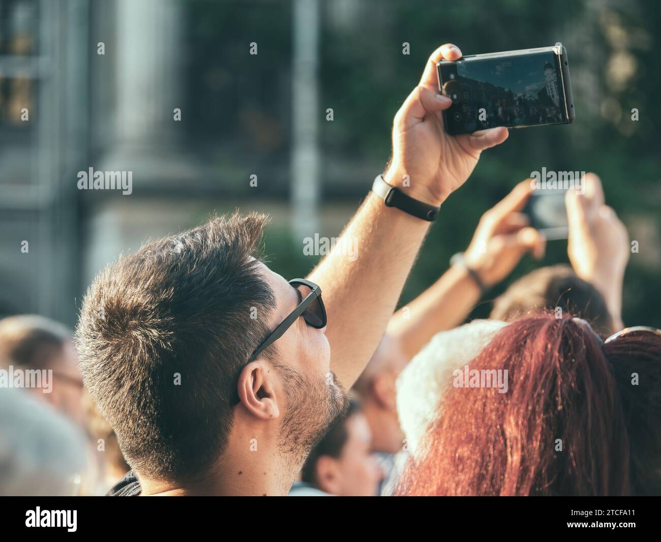 Bucarest, Romania - 17 giugno 2023: Felice turista con uno smartphone che scatta foto nel centro di Bucarest Foto Stock