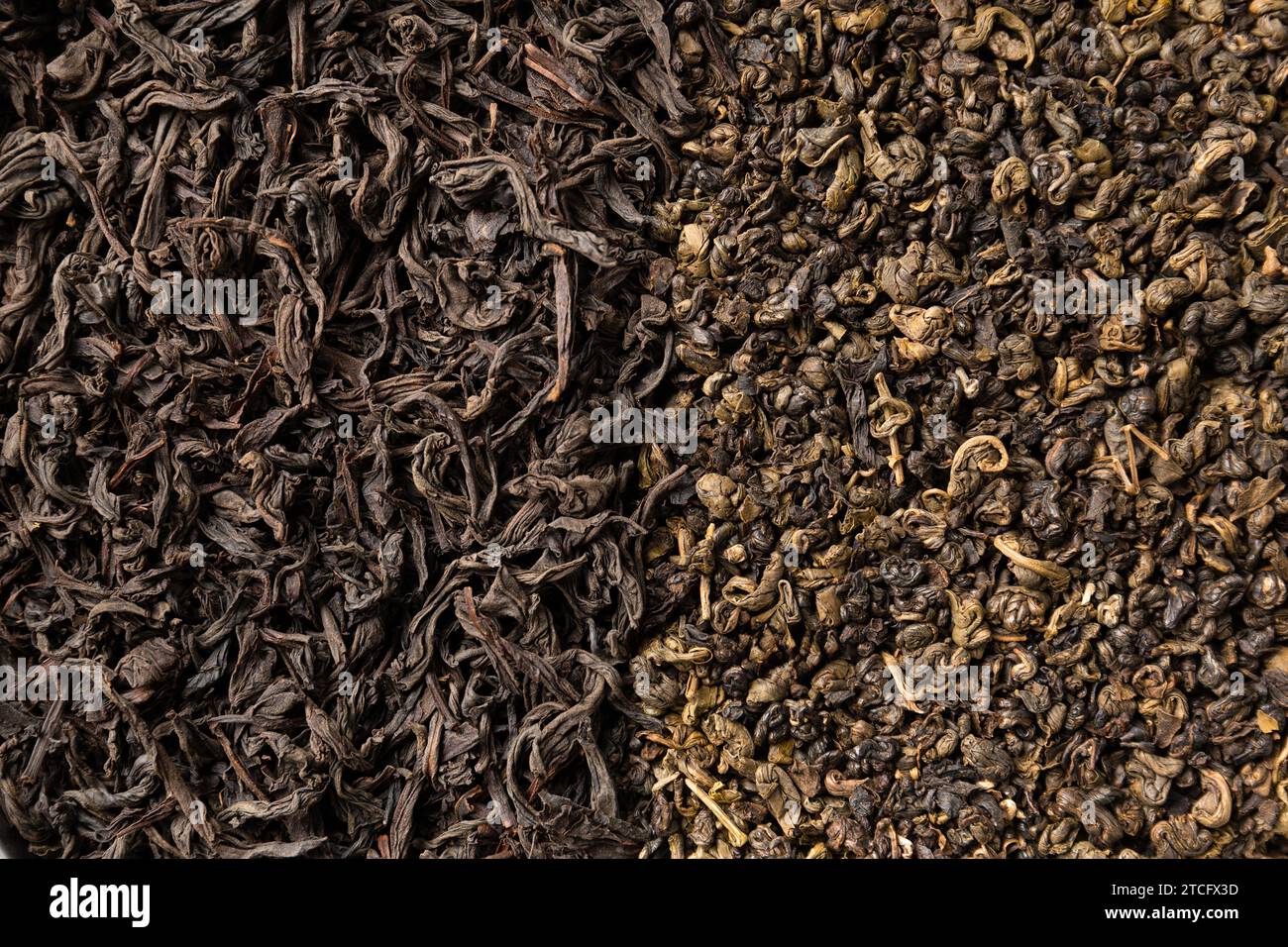 Sfondo di foglie di tè verde e nero secco primo piano con spazio per il testo. Sfondo di foglie di tè. Foto Stock