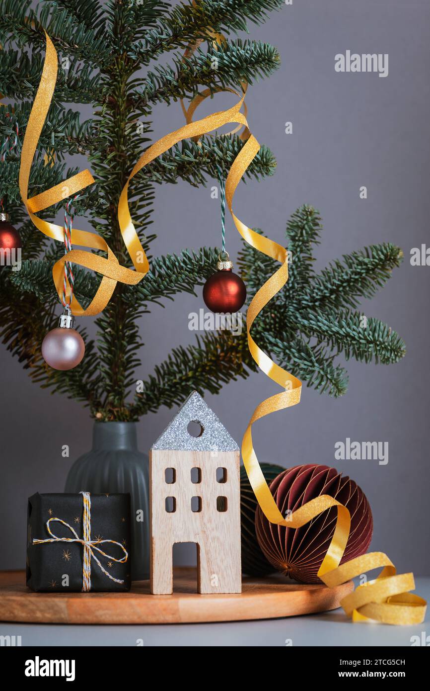 Decorazioni natalizie in legno e confezione regalo, rami di abete su sfondo grigio. Biglietto d'auguri per Natale o Capodanno. Primo piano. Foto Stock