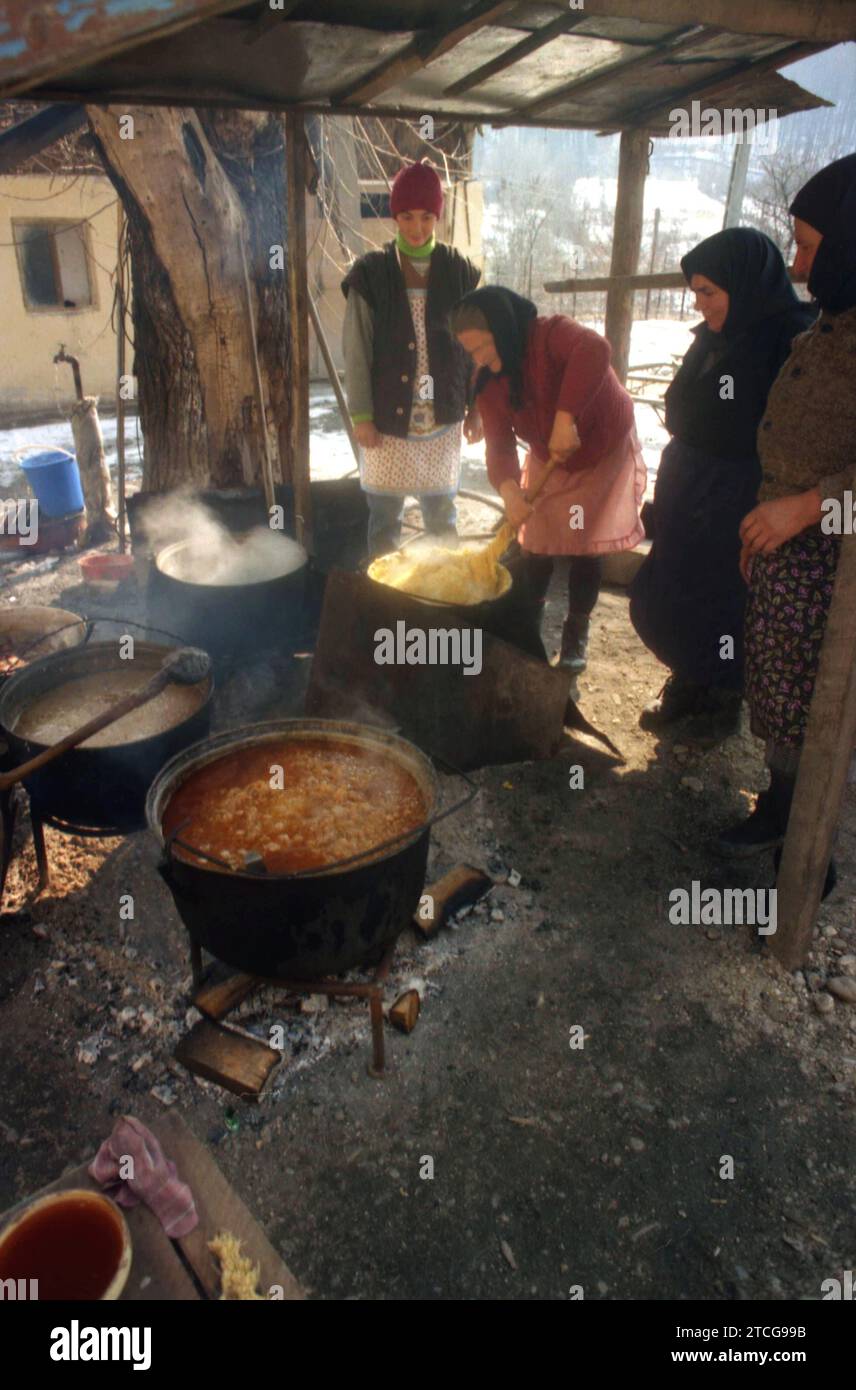 Tutana, Contea di Arges, Romania, 2000. Donne che preparano cibo tradizionale fuori, sopra il fuoco, in grandi calderoni, per un evento nel villaggio. Foto Stock