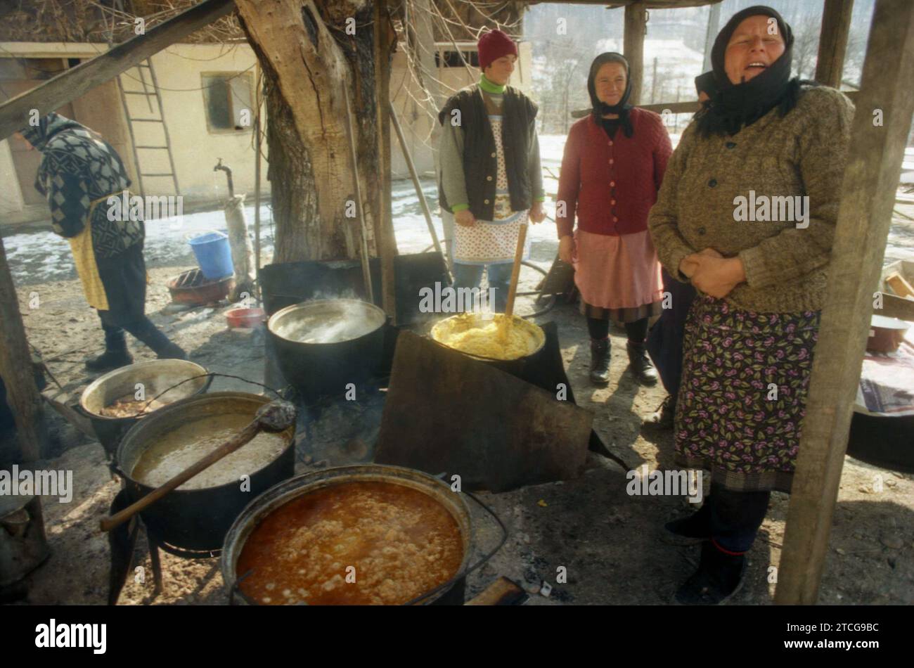 Tutana, Contea di Arges, Romania, 2000. Donne che preparano cibo tradizionale fuori, sopra il fuoco, in grandi calderoni, per un evento nel villaggio. Foto Stock