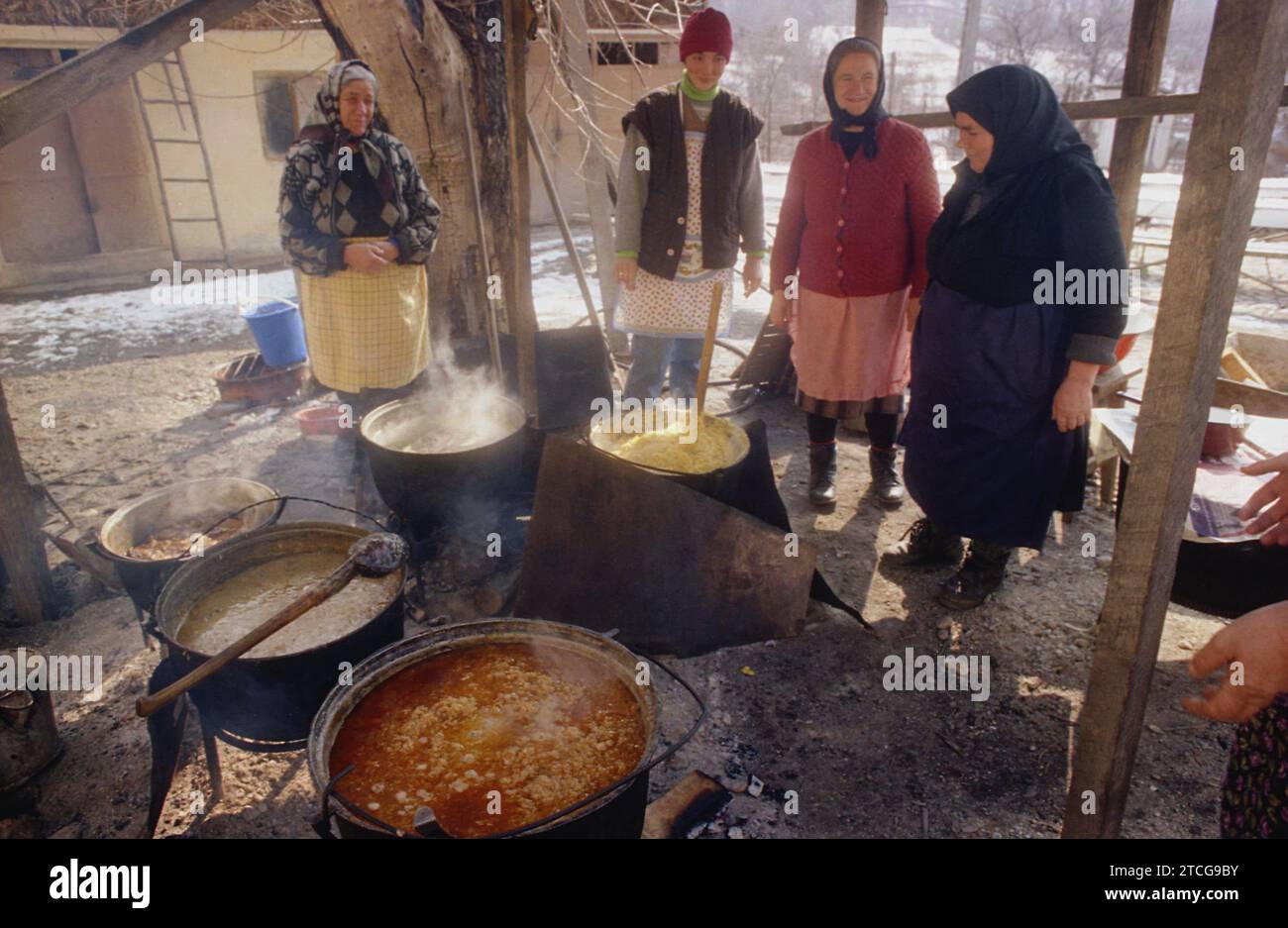 Tutana, Contea di Arges, Romania, 2000. Donne che preparano cibo tradizionale fuori, sopra il fuoco, in grandi calderoni, per un evento nel villaggio. Foto Stock