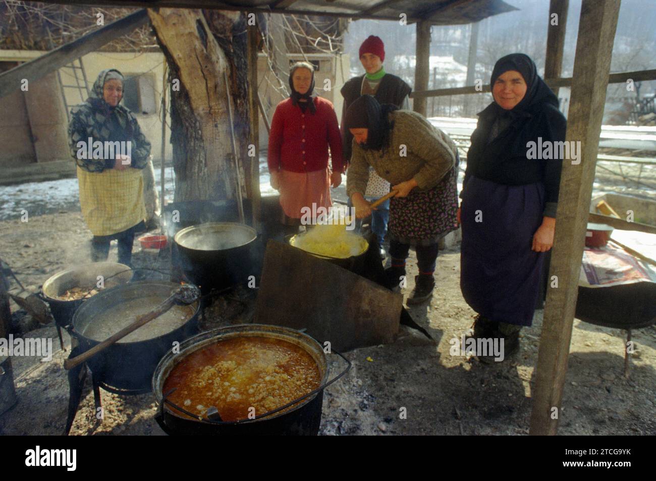 Tutana, Contea di Arges, Romania, 2000. Donne che preparano cibo tradizionale fuori, sopra il fuoco, in grandi calderoni, per un evento nel villaggio. Foto Stock