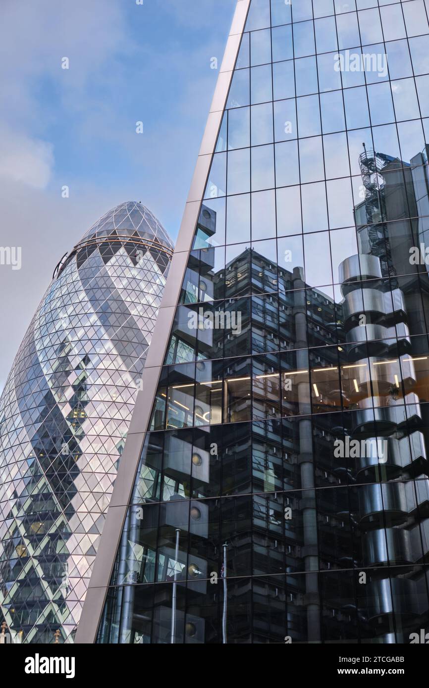 Londra, Regno Unito - 28 ottobre 2023: The Gherkin skyscraper previously and Reflections of Lloyds Insurance in Willis Watson Towers Windows. Foto Stock