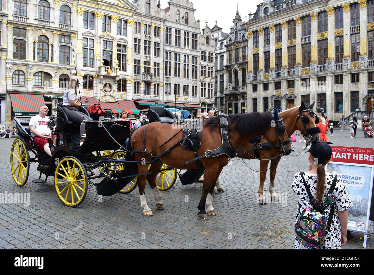 Carrozza con cavalli che porta i turisti alla Grand Place nel centro medievale della città di Bruxelles per un tour panoramico Foto Stock
