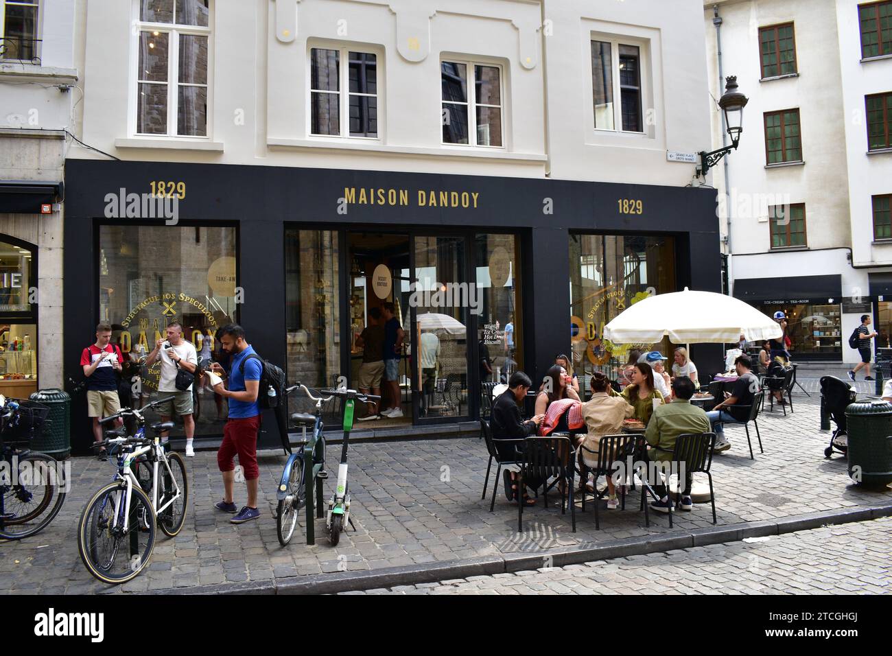 I turisti possono gustare waffle belgi e altri dolci presso la caffetteria "Maison Dandoy" vicino alla Grand Place nel centro medievale di Bruxelles Foto Stock