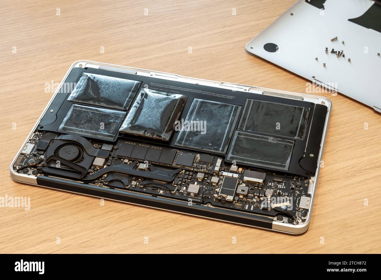 Batteria gonfia del notebook rotto in primo piano con l'involucro aperto. Gravi danni alla diagnostica del notebook durante il servizio di riparazione. Problema con il pc Foto Stock