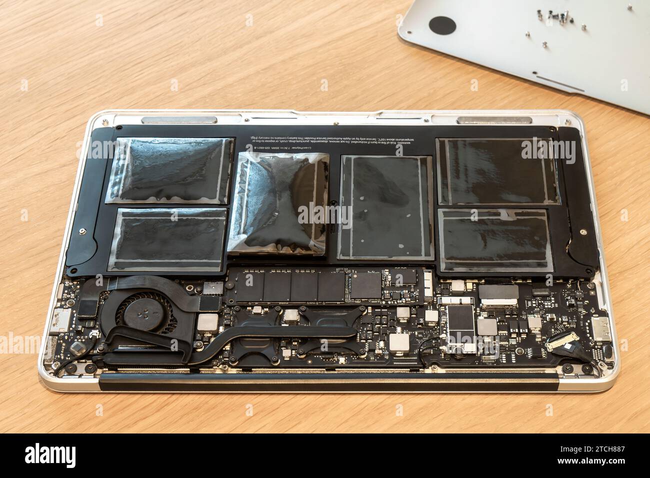 Batteria gonfia del notebook rotto in primo piano con l'involucro aperto. Gravi danni alla diagnostica del notebook durante il servizio di riparazione. Problema con il pc Foto Stock