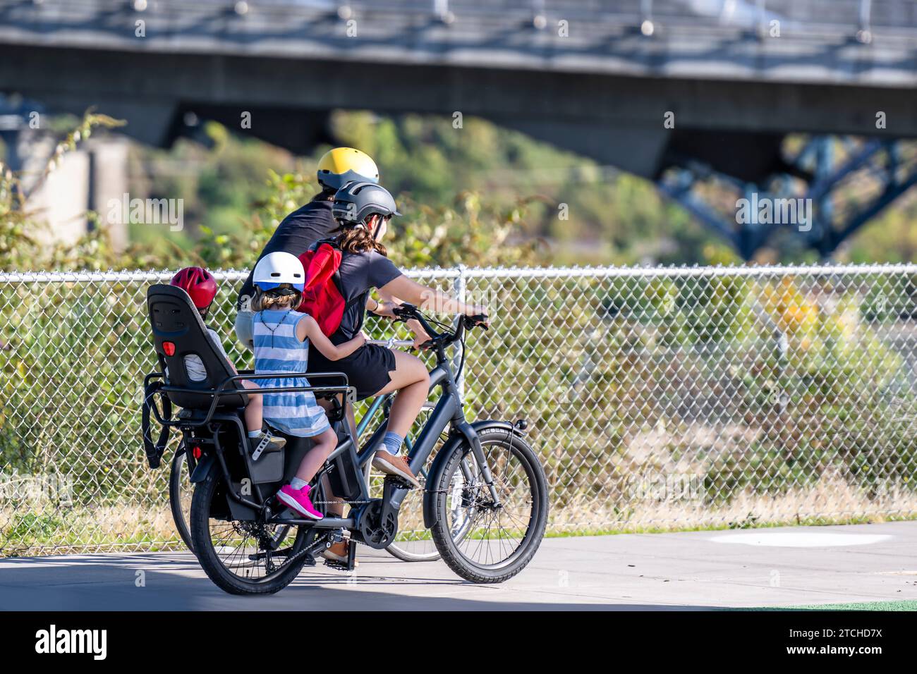 Giro in bici per tutta la famiglia su una pista ciclabile. Utilizzare una bicicletta come mezzo di trasporto principale per molti appassionati è cresciuto da un hobby a una necessità vitale per maintai Foto Stock