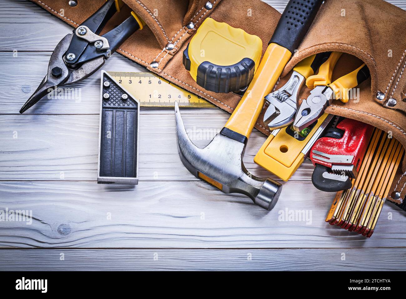 Cintura portautensili in pelle con utensili da costruzione su piastra in legno concetto di manutenzione Foto Stock