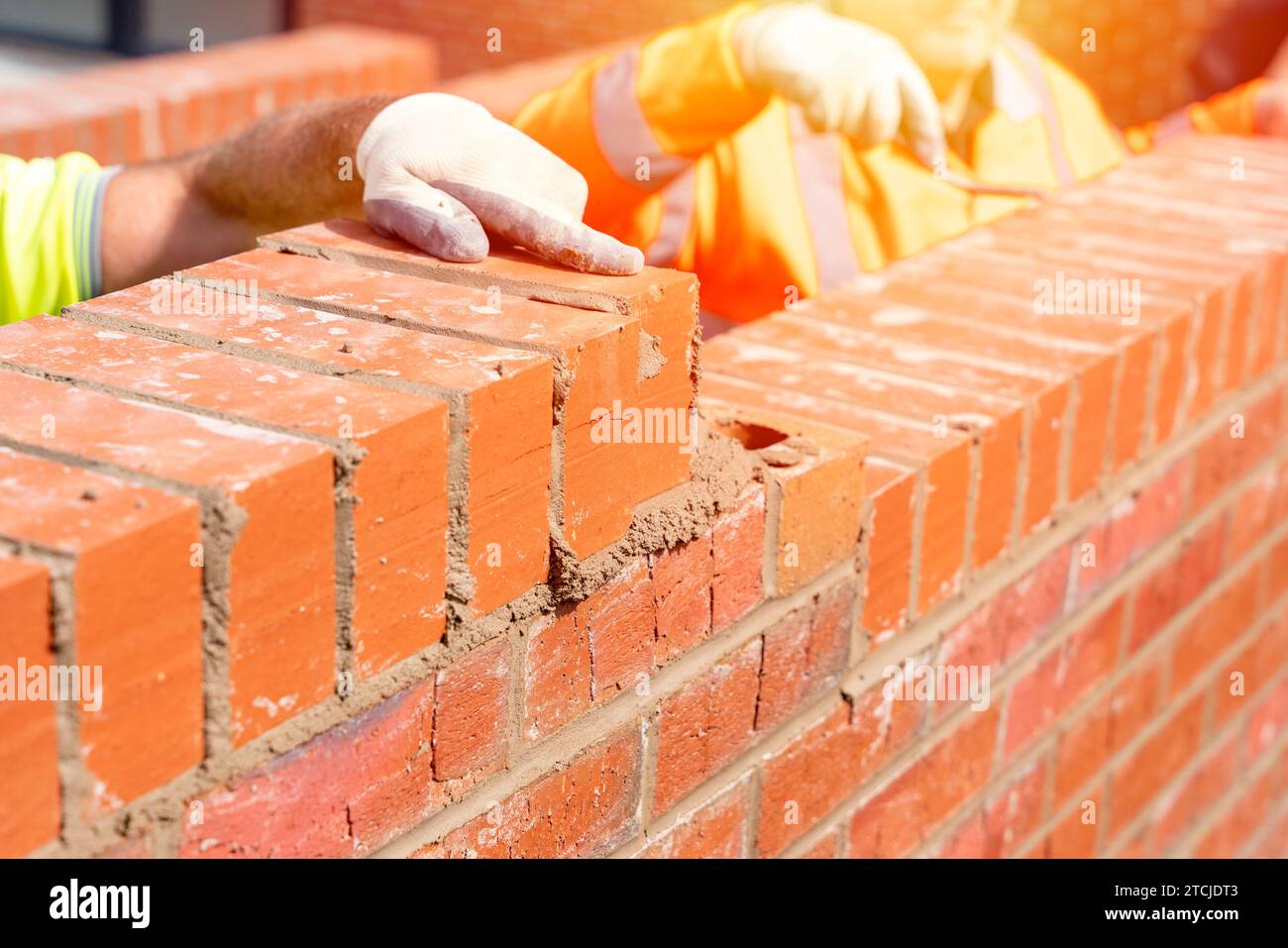 Muratori che posano mattoni su mortaio Foto Stock