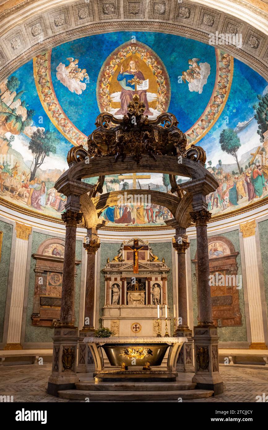 Vista dell'altare in marmo e dei vecchi affreschi decorativi all'interno della storica basilica di Roma Foto Stock