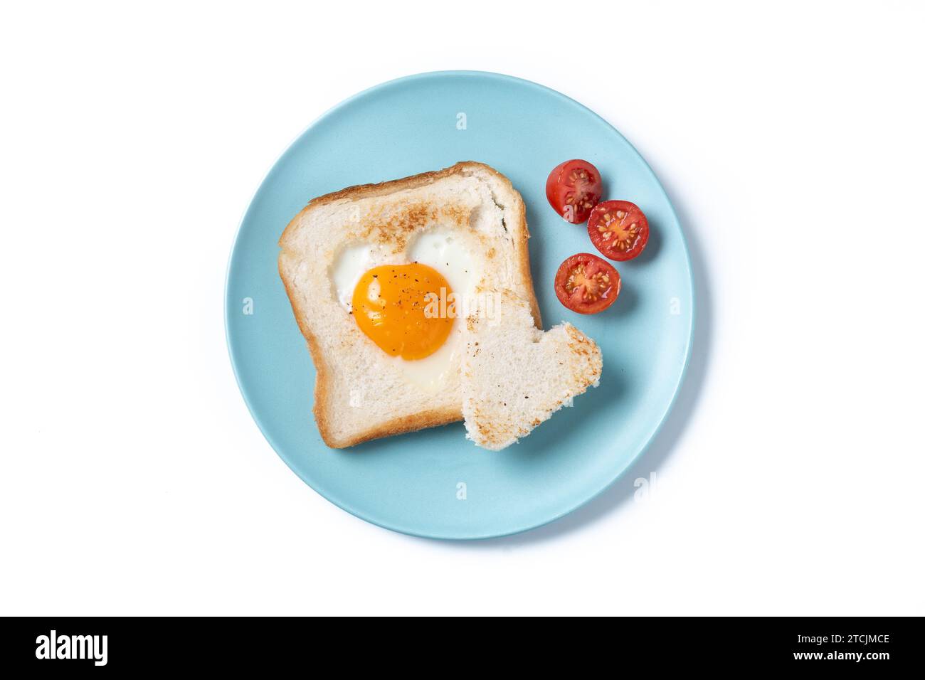 Colazione di San Valentino con uova con pomodori, pane a forma di cuore e pane tostato isolato su sfondo bianco Foto Stock