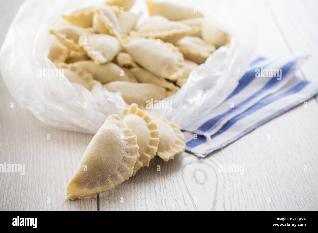 Gnocchi crudi con ripieno all'interno, cucina Ucraina. Gnocchi crudi da congelare in una borsa su un tavolo di legno chiaro. Cucina casalinga. Foto Stock