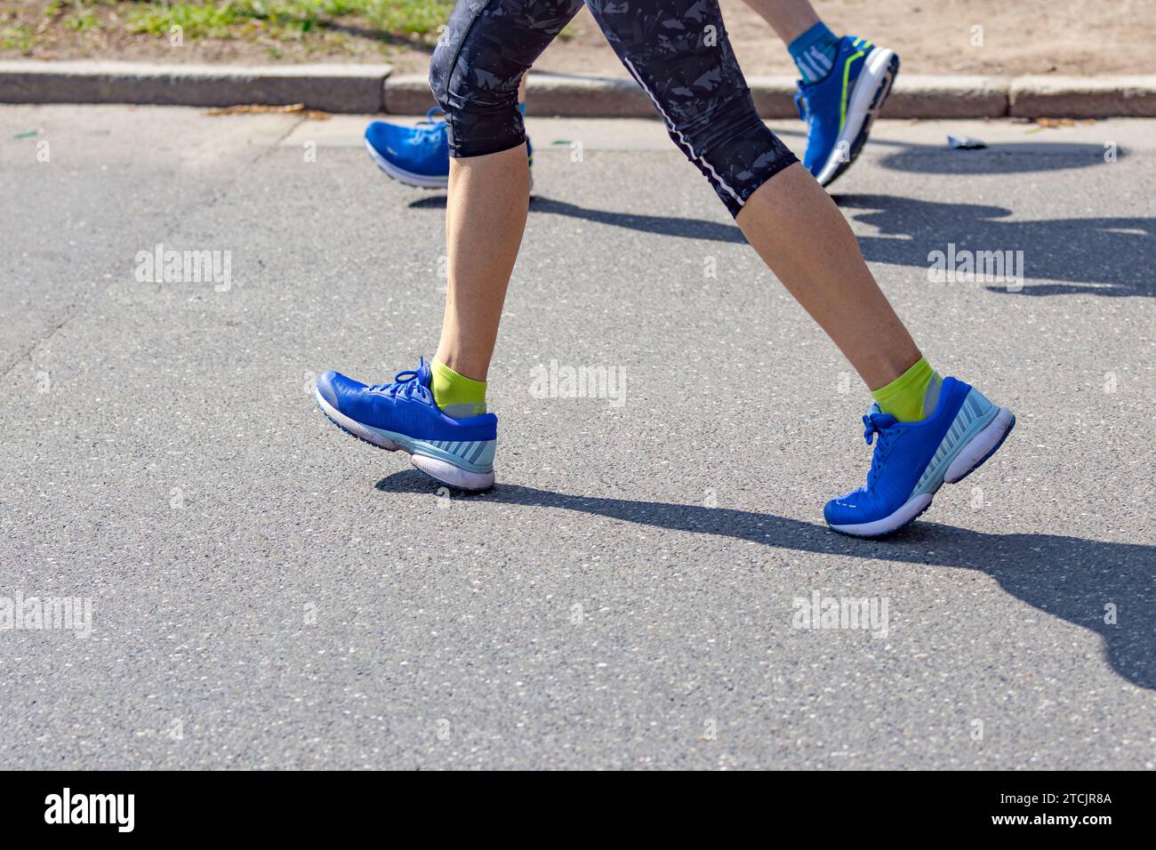 Maratoneta femminile con scarpe da running blu sull'asfalto Foto Stock