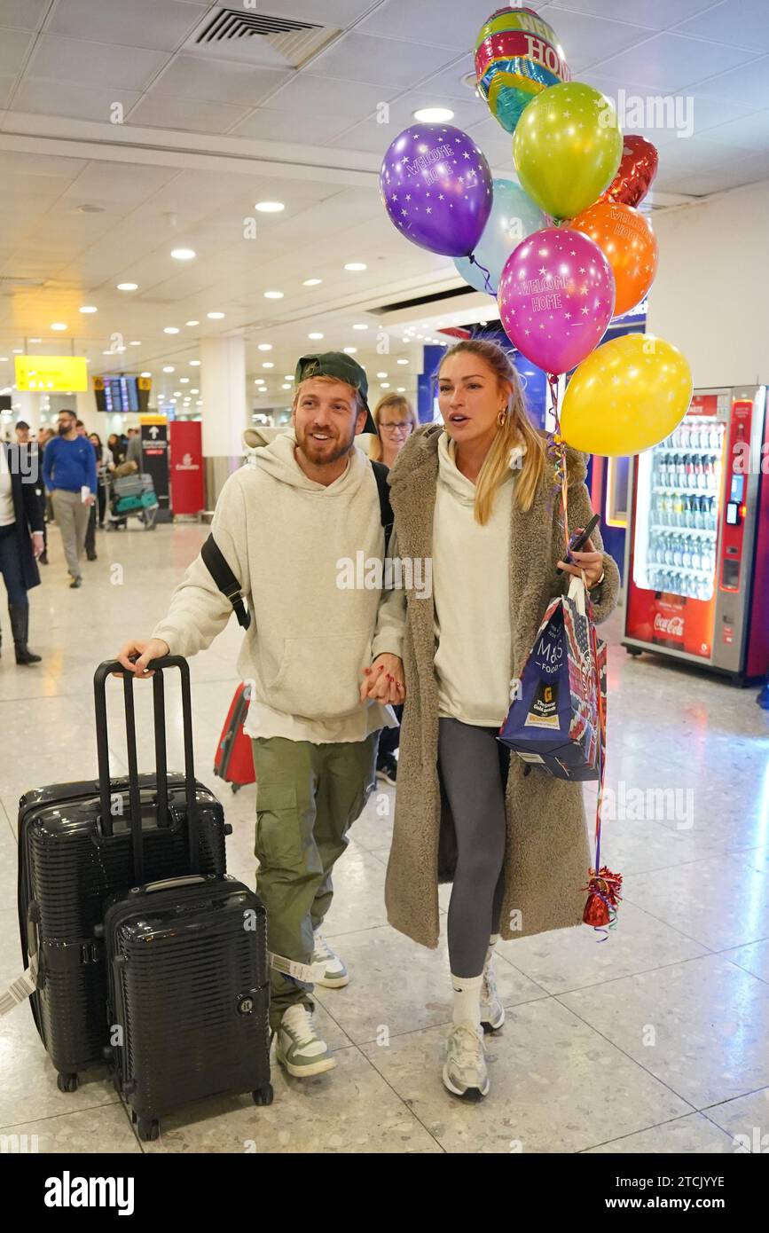 Il vincitore della serie Sam Thompson (a sinistra) viene accolto da Zara McDermott all'aeroporto di Heathrow, Londra, dopo aver preso parte alla serie ITV i'm A Celebrity Get me Out of Here! In Australia. Data foto: Mercoledì 13 dicembre 2023. Foto Stock