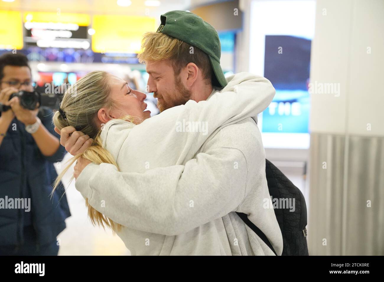 Il vincitore della serie Sam Thompson (a destra) viene accolto da Zara McDermott all'aeroporto di Heathrow, Londra, dopo aver preso parte alla serie ITV i'm A Celebrity Get me Out of Here! In Australia. Data foto: Mercoledì 13 dicembre 2023. Foto Stock