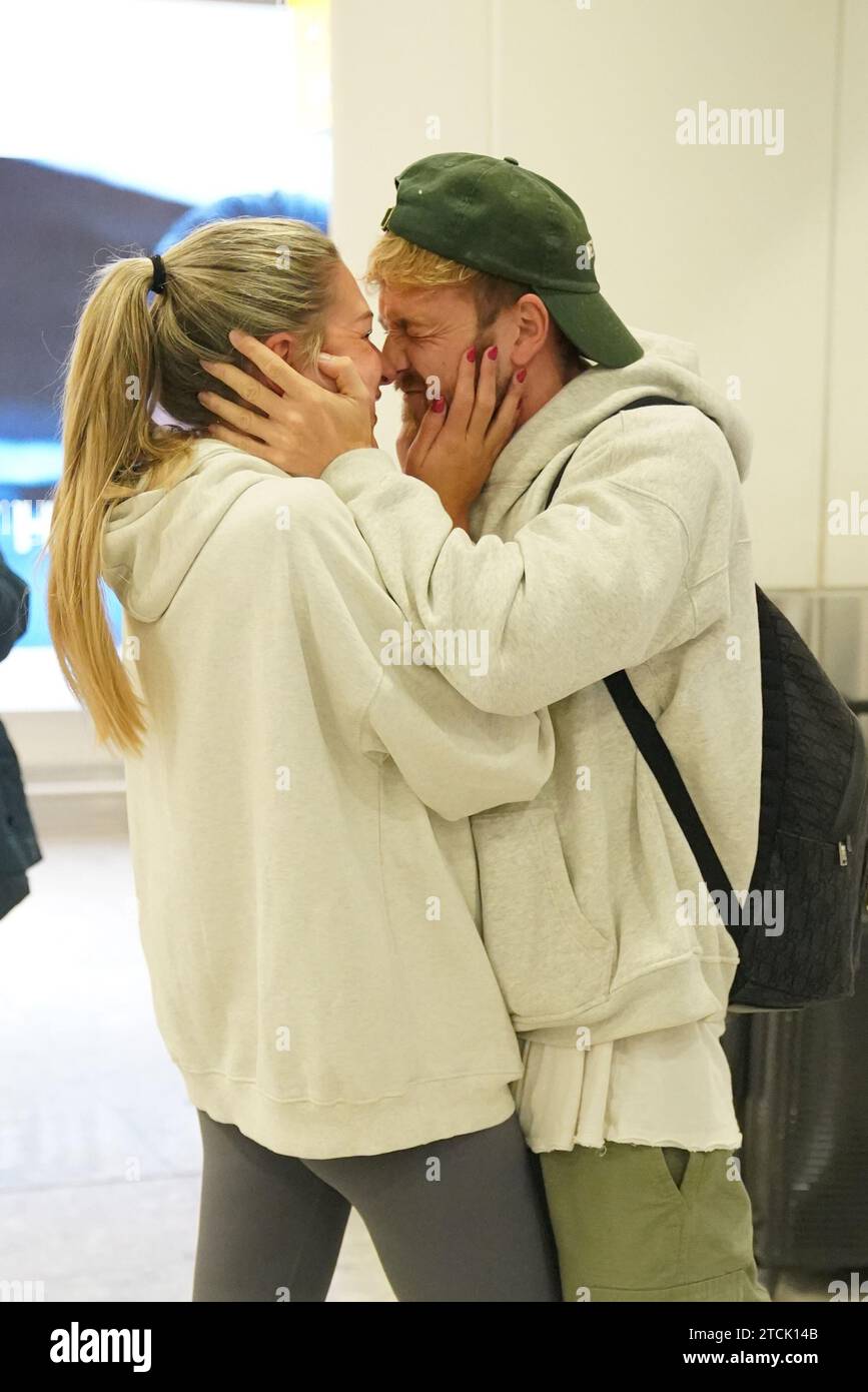 Il vincitore della serie Sam Thompson (a destra) viene accolto da Zara McDermott all'aeroporto di Heathrow, Londra, dopo aver preso parte alla serie ITV i'm A Celebrity Get me Out of Here! In Australia. Data foto: Mercoledì 13 dicembre 2023. Foto Stock