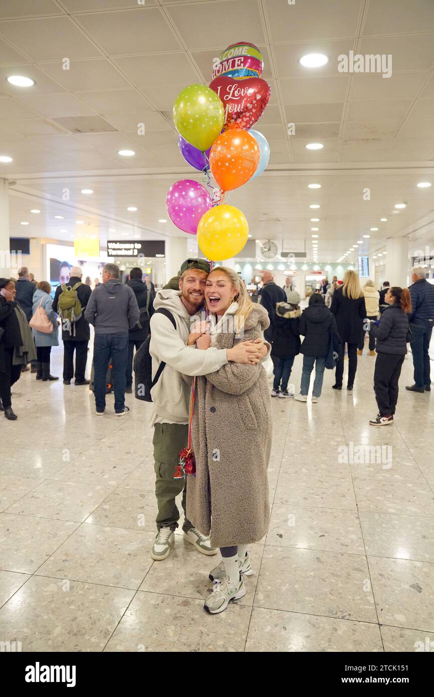 Il vincitore della serie Sam Thompson (a sinistra) viene accolto da Zara McDermott all'aeroporto di Heathrow, Londra, dopo aver preso parte alla serie ITV i'm A Celebrity Get me Out of Here! In Australia. Data foto: Mercoledì 13 dicembre 2023. Foto Stock