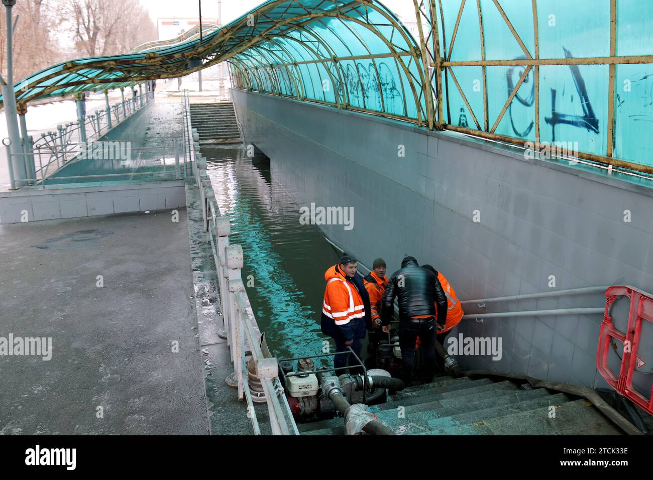 KIEV, UCRAINA - 13 DICEMBRE 2023 - i lavoratori municipali pompano l'acqua da un passaggio sotterraneo inondato dopo che una rete di approvvigionamento idrico è stata danneggiata dalla caduta di detriti missilistici su Voskresenskyi Avenue, Kiev, capitale dell'Ucraina. Mercoledì sera, 13 dicembre, le truppe russe lanciarono missili balistici 48Í6 dal sistema missilistico S-400 nella capitale Ucraina. Tutti e 10 i proiettili sono stati intercettati dai sistemi di difesa aerea ucraini. Come riportato, 53 persone hanno subito ferite. Venti persone, tra cui due bambini, sono state ricoverate in ospedale. Foto Stock