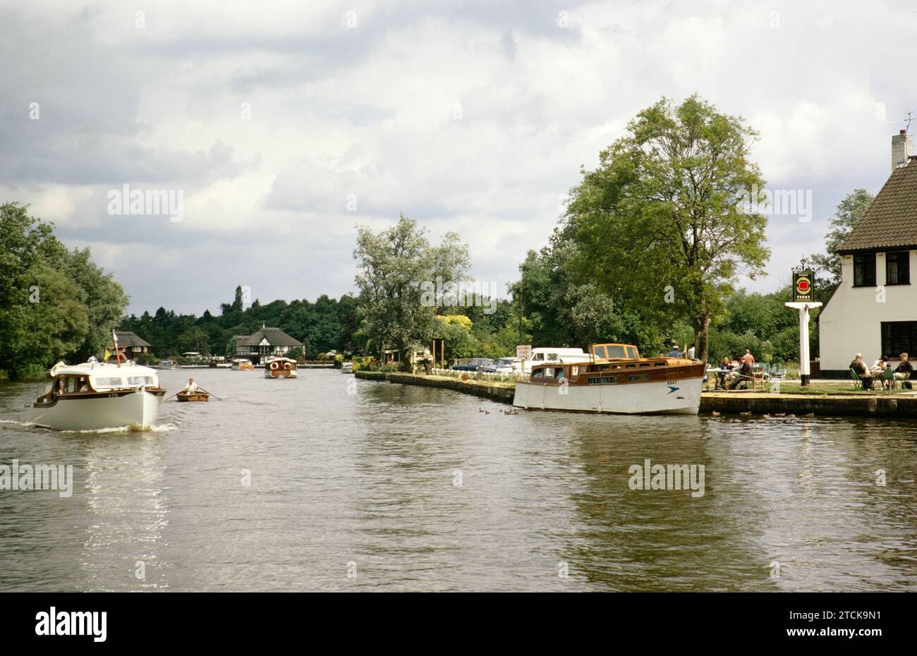 Barche e case storiche nel villaggio di Horning, Norfolk Broads, Norfolk, Inghilterra, Regno Unito, luglio 1970 Foto Stock