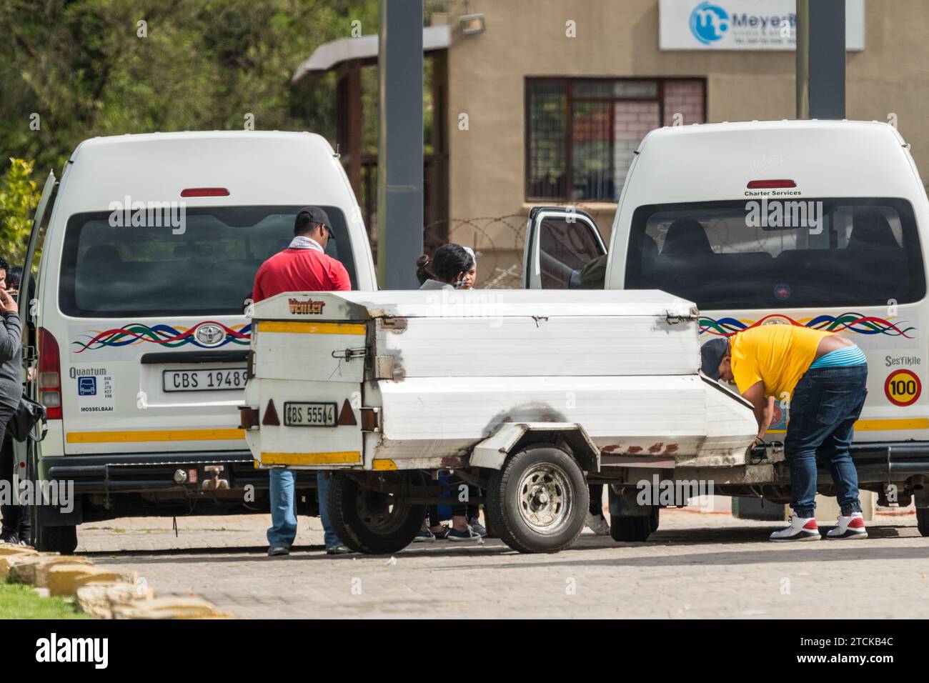 Aggancia un rimorchio a un minibus taxi prima di un lungo viaggio su strada con i mezzi pubblici in Sud Africa, concetto di trasporto a lungo raggio Foto Stock