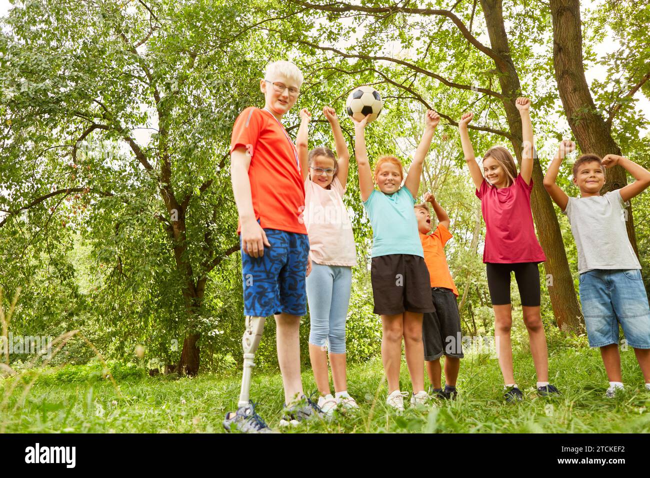 Ritratto di amici maschili e femminili che applaudono mentre giocano a calcio al parco Foto Stock