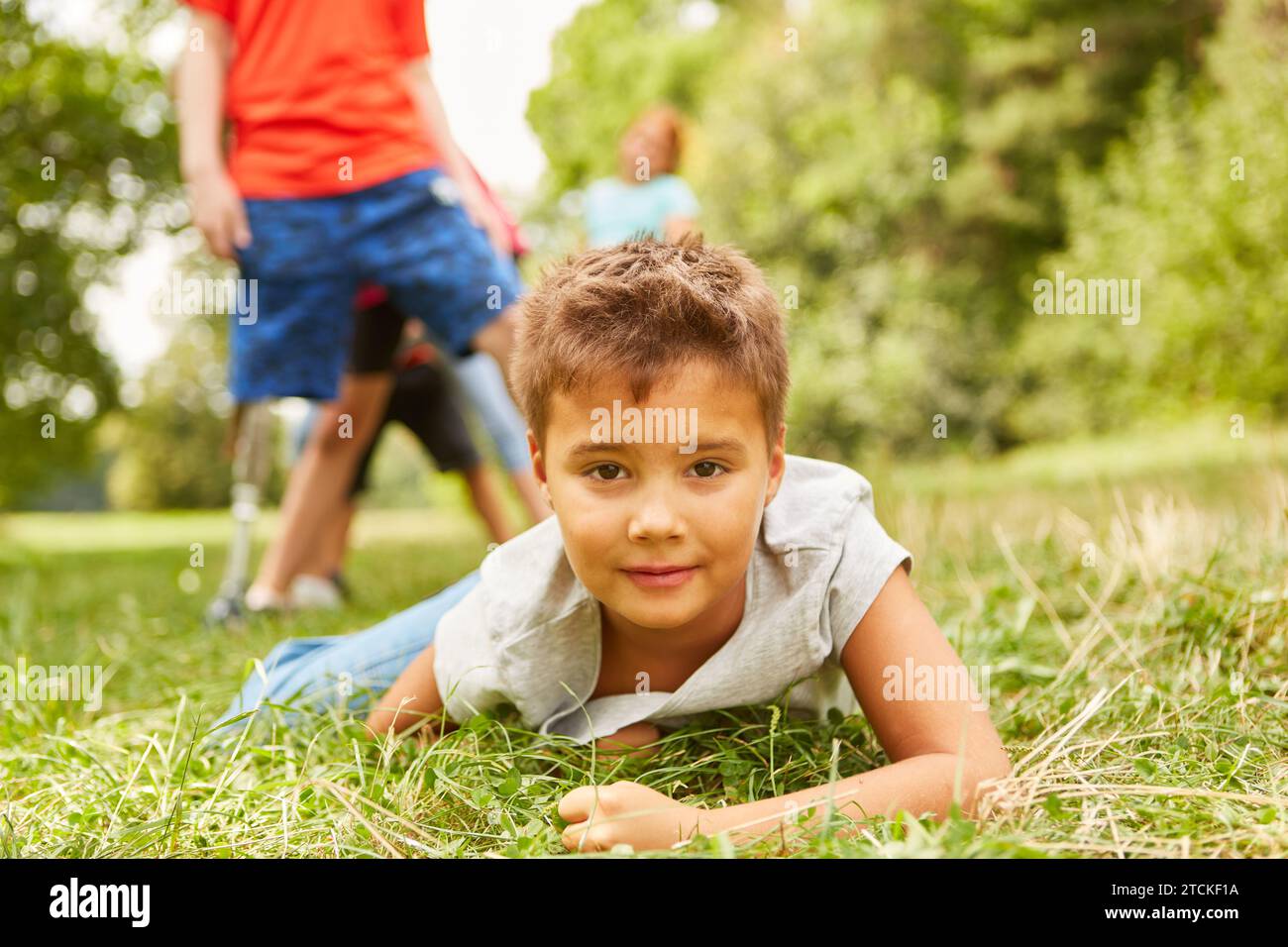 Ritratto di un ragazzo sdraiato sull'erba mentre giocava al parco Foto Stock