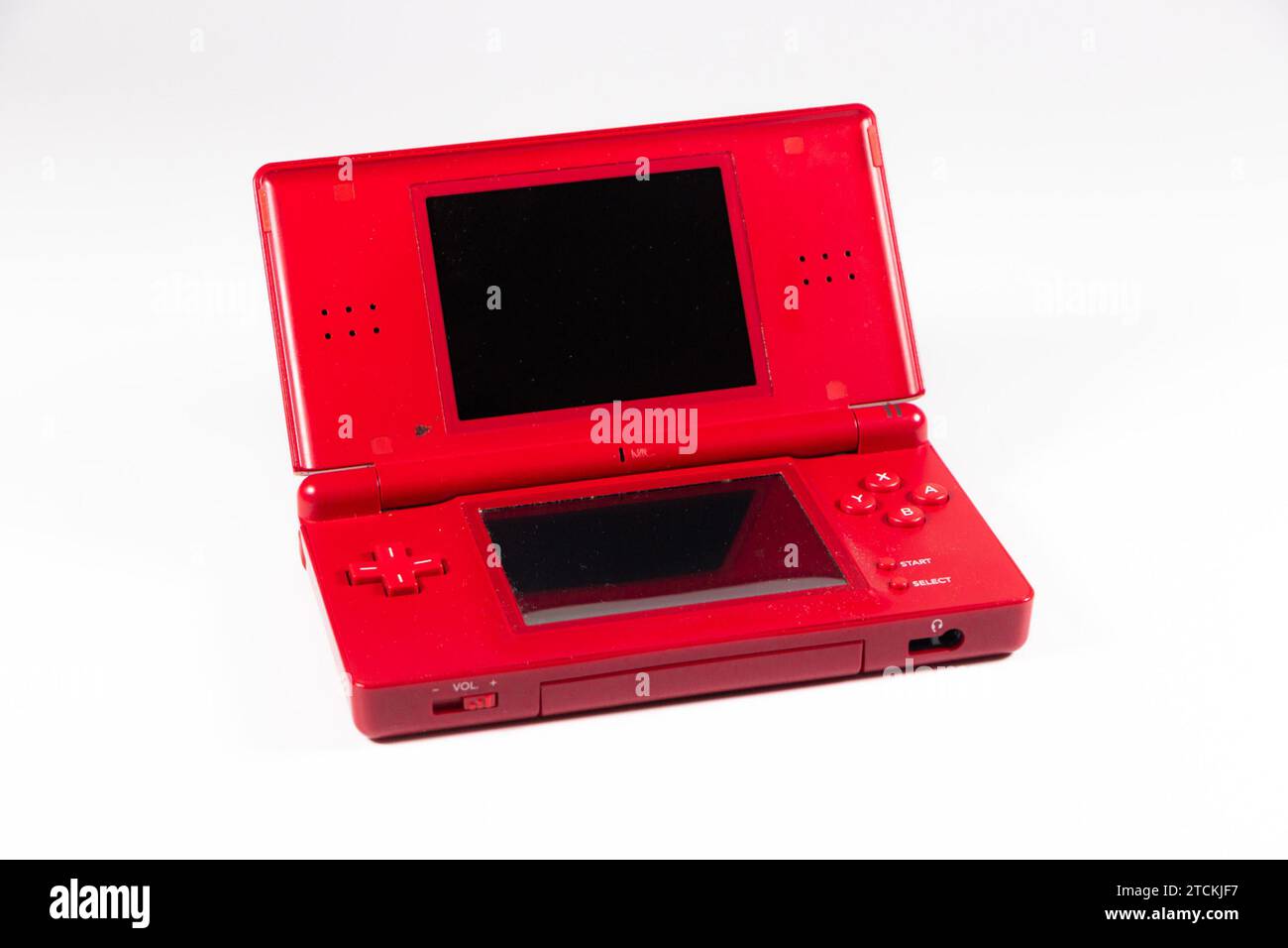 Console di gioco portatile portatile Nintendo DS lite in plastica rossa isolata sullo sfondo dello studio con accessori e scheda Foto Stock