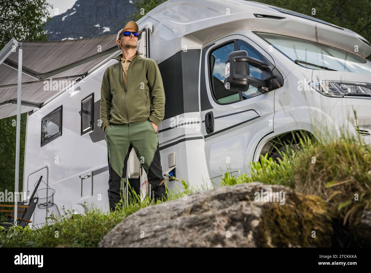 Fiero proprietario di camper per per veicoli ricreativi davanti al suo veicolo. Moderno tema campeggio. Foto Stock
