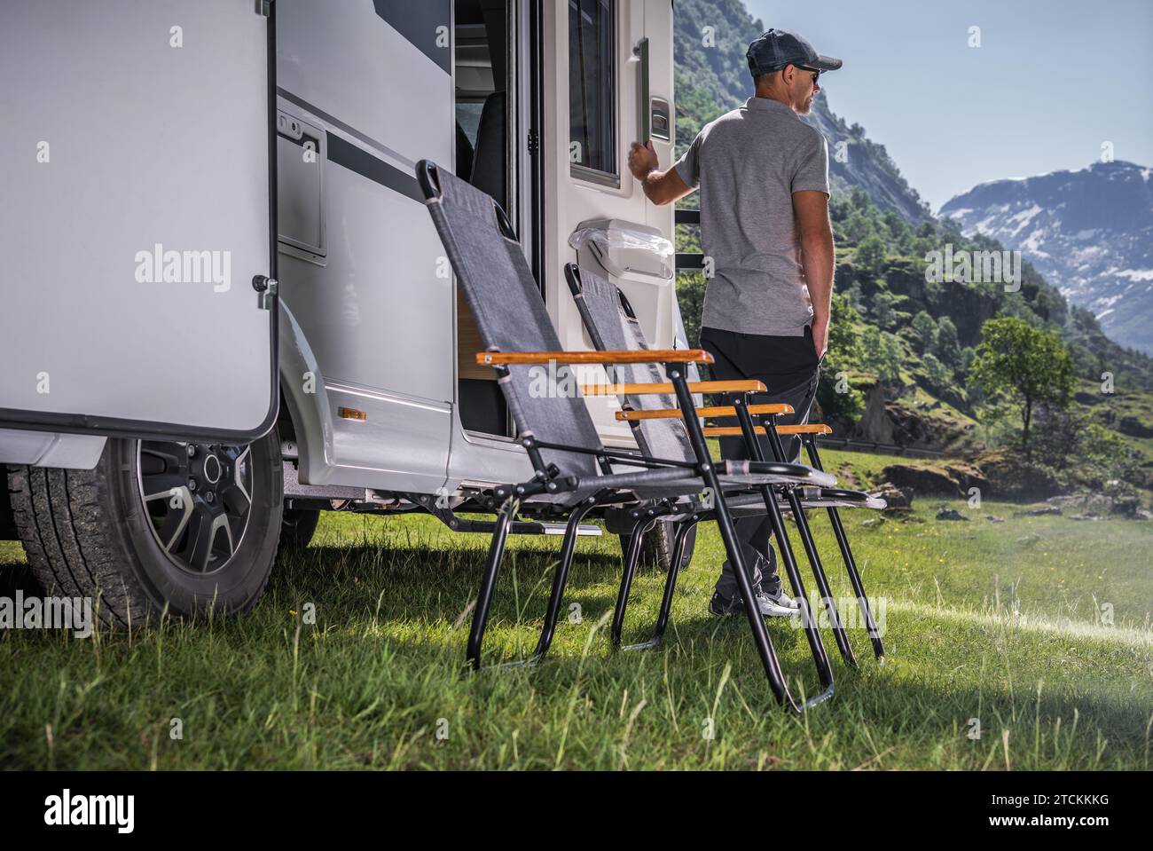 Vacanza in un veicolo ricreativo. Proprietario di camper caucasico davanti al suo veicolo. Foto Stock